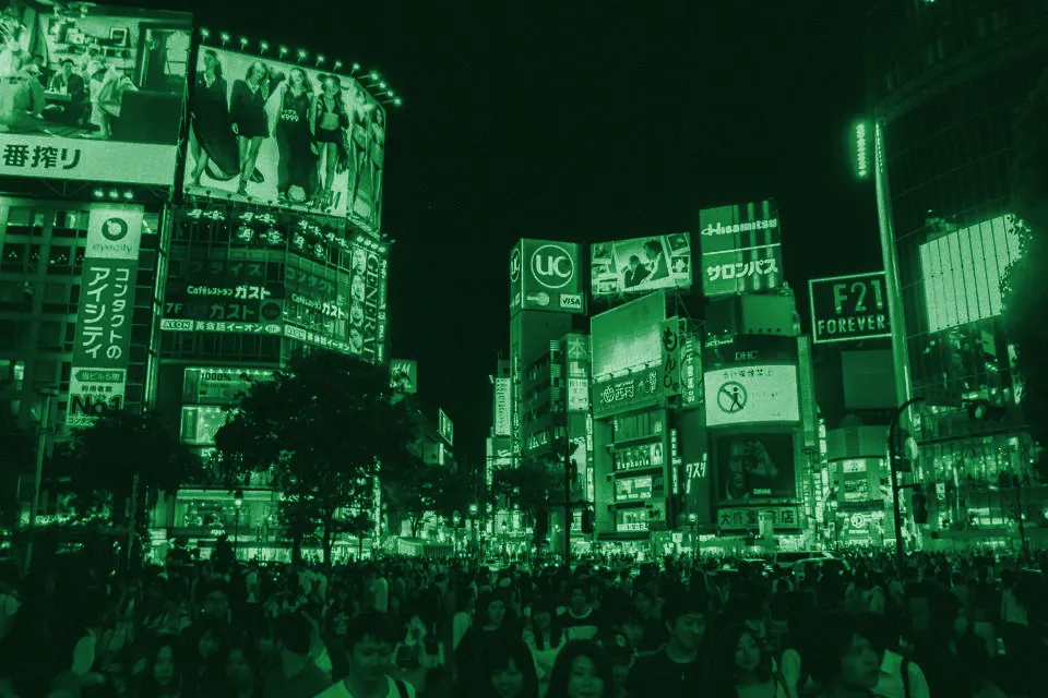 Crowded city crossing surrounded by illuminated billboards